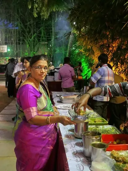 Guests enjoying a variety of dishes from a buffet line at an outdoor event. I ensure there is a wide selection to cater to different tastes.