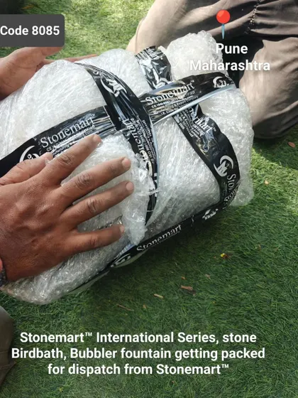 The stone birdbath and bubbler fountain is carefully wrapped before being placed in its crate.