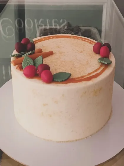 A slightly different view of the rustic anniversary cake, showing the subtle texture and the arrangement of the handcrafted fondant decorations.