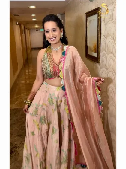 The happy bride, her floral hairstyle perfectly complementing her pastel lehenga.