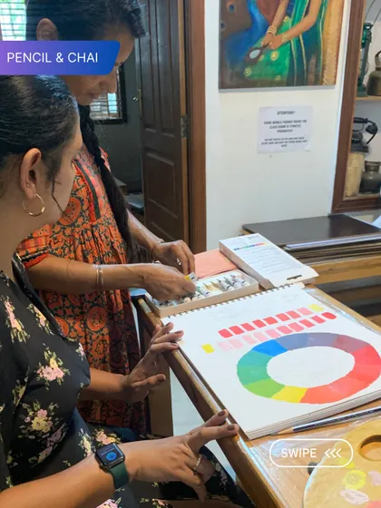 Understanding color is fundamental. Here, I explain the color wheel to a student, a crucial lesson in our foundation courses that underpins all future painting work.