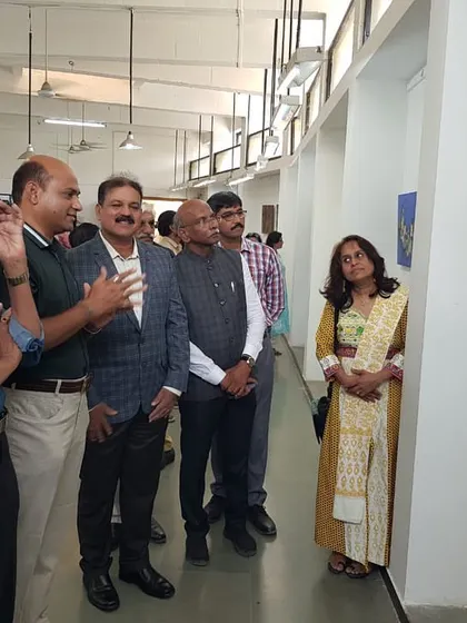 Explaining my artwork to the Hon. Dr. B. G. Shekhar, Special Inspector General of Police, during the Janasthan Group's art exhibition.