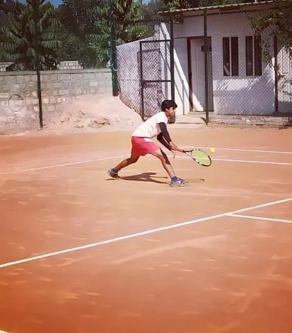 A junior player demonstrates excellent form on a forehand shot during the Open Tournament.