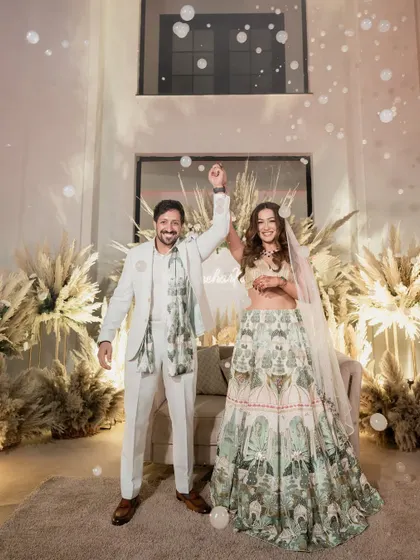 The couple celebrating their union with a bubble-filled moment of joy. The pampas grass decor in the background adds to the dreamy, boho vibe.