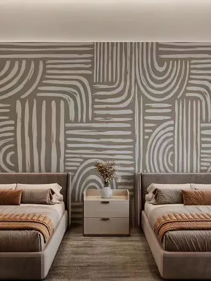 This bedroom features a unique wallpaper with geometric patterns. The twin bed setup is ideal for a shared guest room or kids' room.