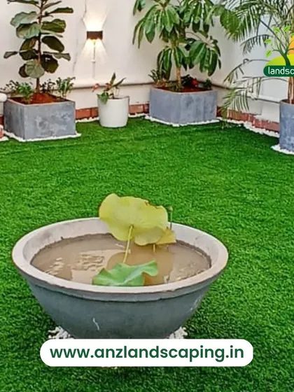 A simple yet elegant terrace setup combining high-quality artificial turf with a variety of potted plants, including a lotus bowl, to create a peaceful, green space.