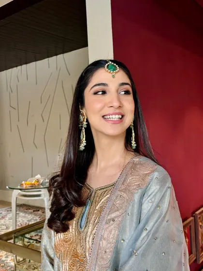A happy, candid shot of the bride. Her makeup is fresh and radiant, perfect for a daytime event.