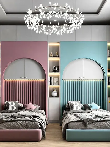 A perfectly symmetrical shared bedroom for two siblings. The room is divided into pink and blue themes, with each side featuring a custom bed with a fluted headboard, built-in bookshelf, and wardrobe.