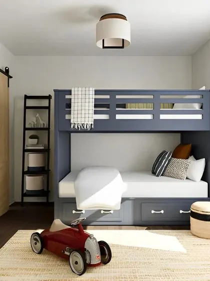 We designed this classic boys' room with a sturdy blue bunk bed that includes two large storage drawers. The room is styled with a rustic sliding barn door and a simple ladder shelf, creating a timeless and practical space.