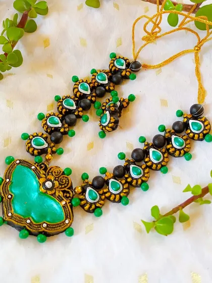 A beautiful butterfly-pendant necklace in green and black. The heart-shaped pendant and delicate chain make it a lovely piece.