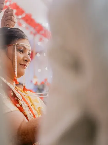 A beautifully framed, candid shot of the bride during a quiet moment in the ceremony.