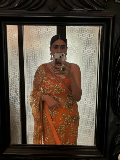 A mirror selfie before heading to the palace wedding. This gives a closer look at the intricate sequin and thread work on my orange saree.