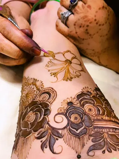 A moment from a birthday henna session, showing the creation of a delicate flower. I use only pure, organic henna for all my clients.