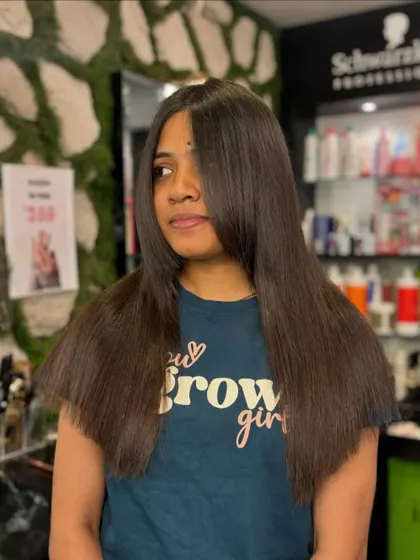 This client is enjoying the results of a hair smoothening treatment. Her hair is transformed into a silky, straight, and perfect style.