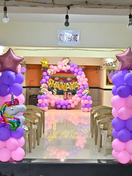 A view from the entrance of the party hall, showing the balloon pillars and the main backdrop.