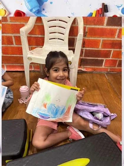 Another student displays her lovely drawing, showing the skills and confidence she's gaining in our art classes.