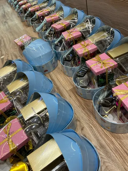 A row of my signature blue cradle-shaped gift baskets, all packed and ready to be sent out for a baby boy announcement.