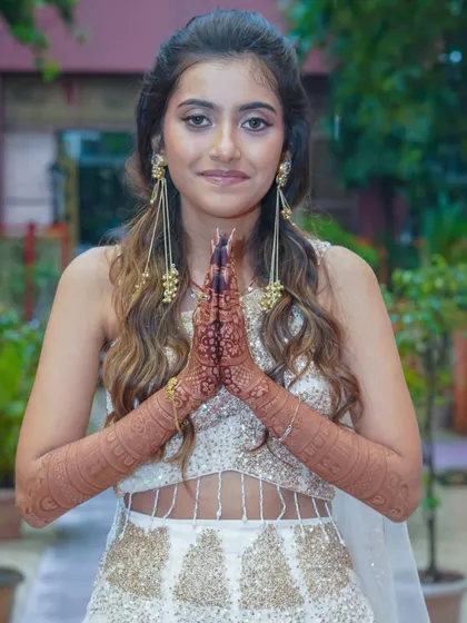 This bride looks absolutely radiant. Her henna stain is a beautiful complement to her elegant white and gold lehenga.