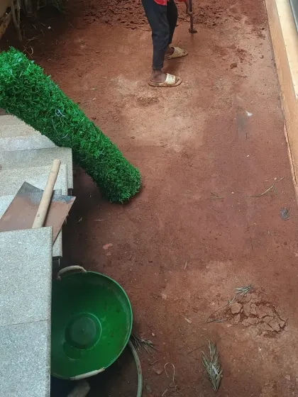 The turf has been unrolled and is ready for cutting and fitting into the prepared space.