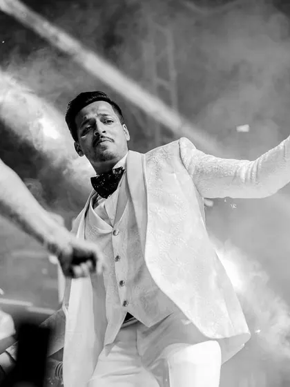 A dynamic black and white shot of the groom dancing, captured with dramatic lighting.