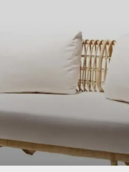 A clean studio view of our two-seater rattan sofa. The open-weave design on the arms and back keeps it feeling light and airy, while the deep seat ensures comfort.