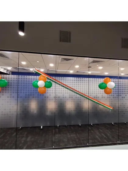 I used simple tricolor balloon clusters on the frosted glass walls of the DQS office. This is an effective way to continue the theme in meeting rooms and along corridors without blocking visibility.