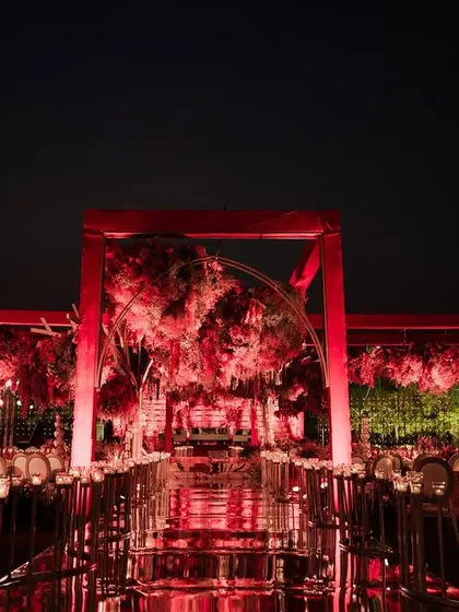 The architectural beauty of the all-red mandap stands out against the night sky. The clean lines of the structure combined with the lush, organic florals created a perfect balance of modern design and timeless romance.