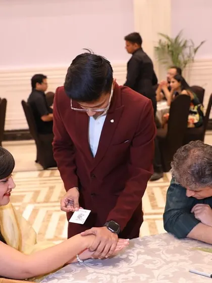 They say magic is the only honest profession because I promise to deceive you, and I do. Here I am performing a close-up trick for guests at their table.