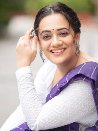 A happy, close-up portrait of Spruha Varad, highlighting the silver jhumkas that complete her contemporary saree look.