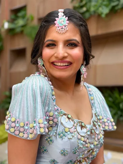 A vibrant and colorful look for a Haldi or carnival event, with a pastel blue outfit and floral jewelry.