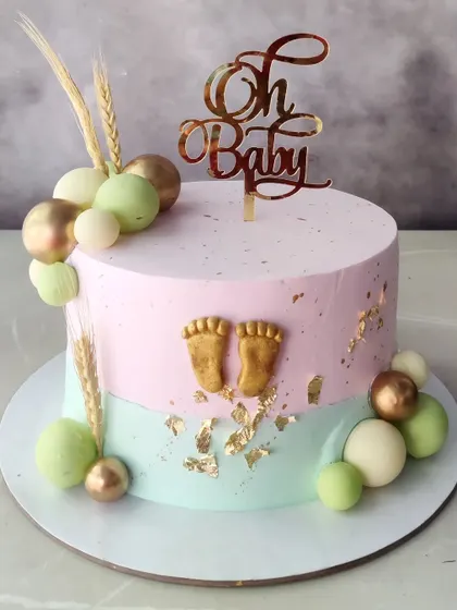 A beautiful and aesthetic "Oh Baby" cake, perfect for a modern baby shower. The soft pastel colors, gold accents, and tiny baby feet make it an elegant centerpiece.
