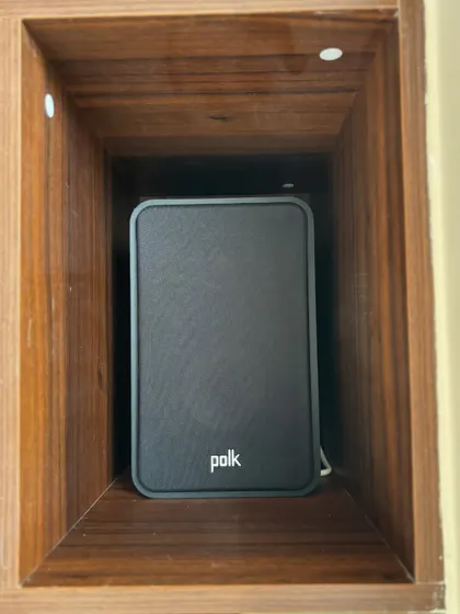 Here is a Polk bookshelf speaker neatly placed inside a wooden shelving unit. I can work with your existing furniture and interior design to integrate the speakers in a way that is both acoustically sound and visually pleasing.