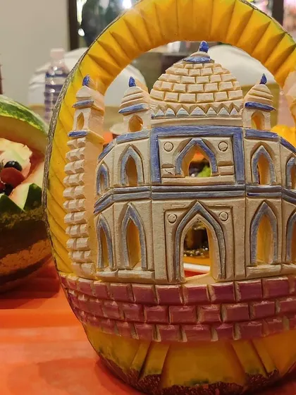 A masterpiece of food art. This is a pumpkin intricately carved to resemble the Taj Mahal, a symbol of love perfect for a wedding celebration.