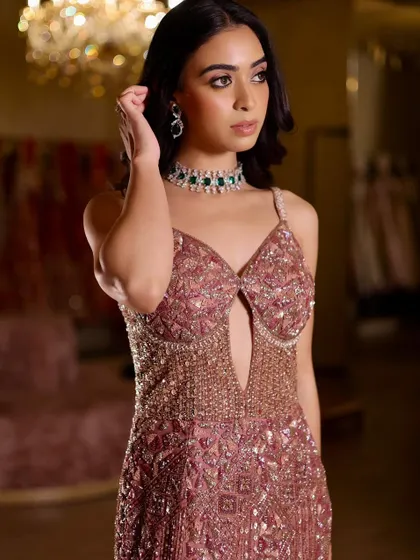A full-length shot of the stunning embellished gown. The makeup is designed to complement the outfit's glamour without overpowering it.