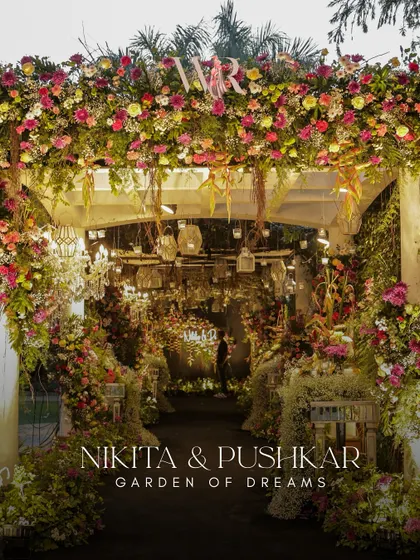 The entrance to the 'Garden of Dreams', a lush floral archway that makes a stunning first impression. The design is dense with colorful flowers, creating a feeling of entering a secret, magical garden.