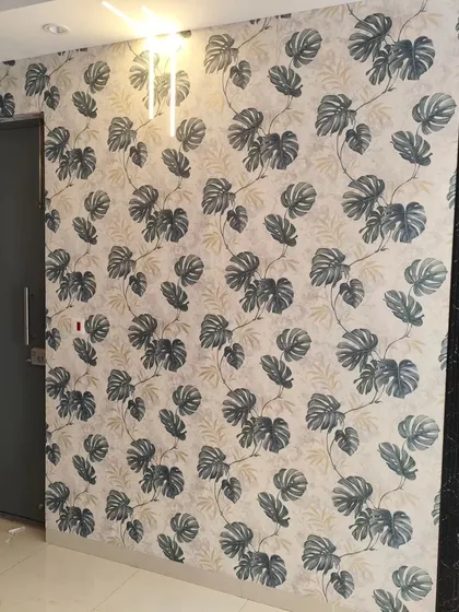 A stylish hallway featuring a monstera leaf wallpaper, creating a modern and welcoming entrance.