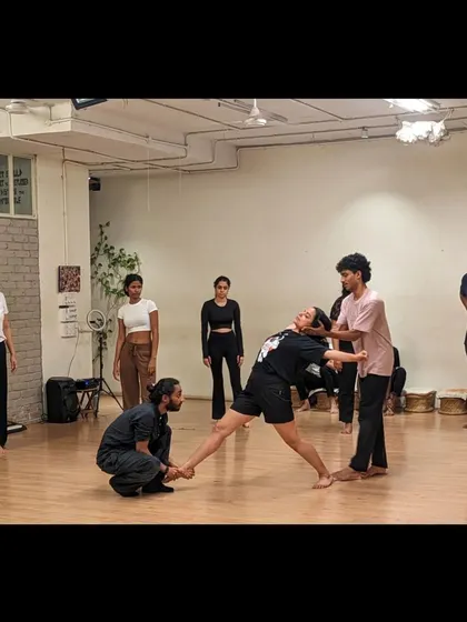 An instructor provides hands-on assistance to ensure a student's safety and proper form during a more complex move.