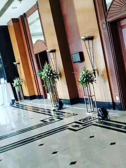 The decor extends to the entire venue. Here, I have placed tall floral stands along the hotel corridor to create a beautiful passage leading to the main event hall.