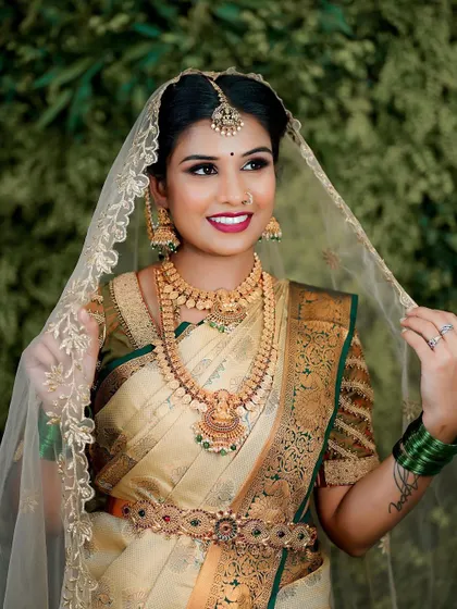 Adjusting her veil, this bride is the picture of grace. Her makeup is designed to be both beautiful and durable, lasting through every moment of her wedding day.