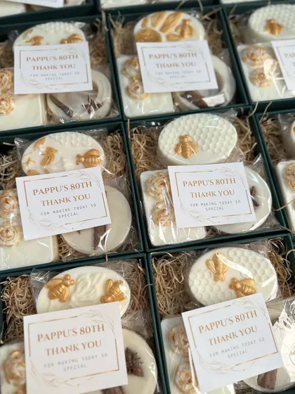 A vintage-themed return favor I created for an 80th birthday party. The white and gold box contains two artisanal soaps and a cinnamon wardrobe freshener.