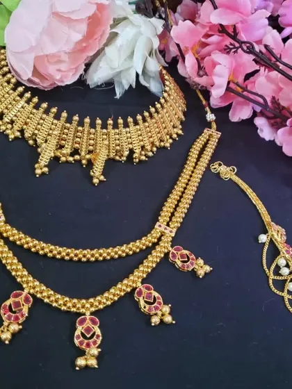 A collection of Maharashtrian and antique style jewellery. The set on the left features a traditional choker and a longer necklace with red stone accents.