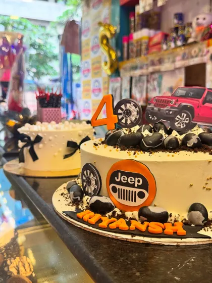A side-by-side view of two of my popular designs: the Jeep adventure cake and an elegant black-bowed cake. It shows the variety I offer, from rugged themes to classic elegance.