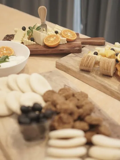 A modern and minimalist presentation of several cheese boards. The arrangement includes a variety of cheeses, crackers, and dips, showcasing a clean and sophisticated approach to gourmet platters.