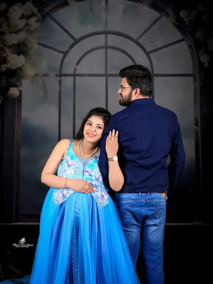 A tender pose with the mom-to-be leaning against her partner. This shot beautifully captures their supportive and loving relationship against an elegant backdrop.