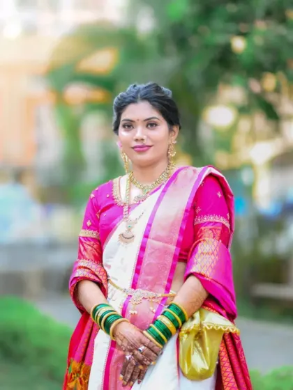 A classic full-length portrait of the bride in her stunning saree, holding the traditional 'pishvi' pouch.