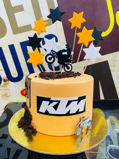 A 1.5kg KTM bike theme cake in the brand's signature orange, with a dirt bike topper.