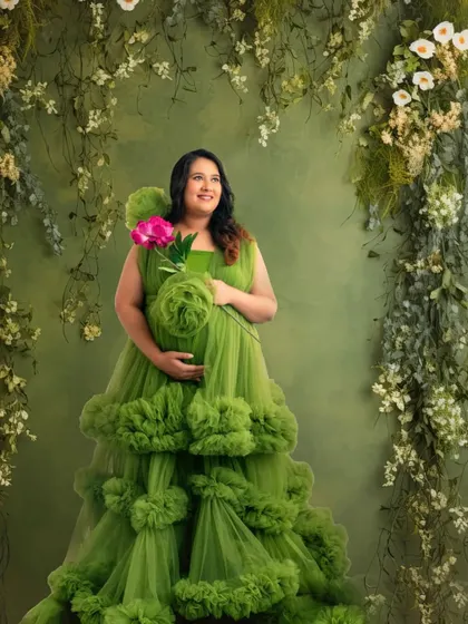 Surrounded by lush greenery, this mom-to-be looks like a woodland goddess. The vibrant green of the gown complements the natural backdrop perfectly.