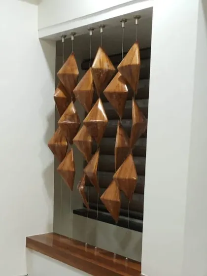 A unique partition design using suspended, diamond-shaped wooden elements. This acts as a beautiful visual screen between two spaces while allowing light and air to pass through.