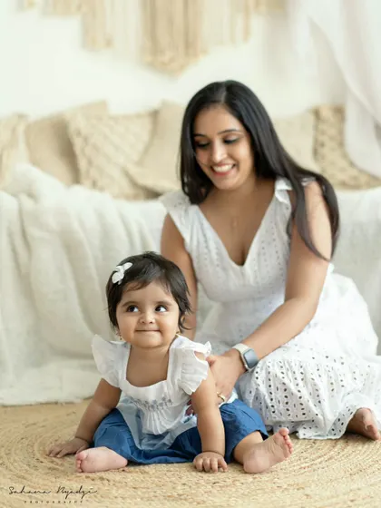 A duplicate of image 74, a mother and daughter in a rustic studio setting. The natural textures and their relaxed poses create a calm and beautiful scene.