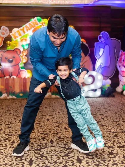A playful moment between father and son at his second birthday party. These fun, interactive shots are just as important as the posed family portraits.